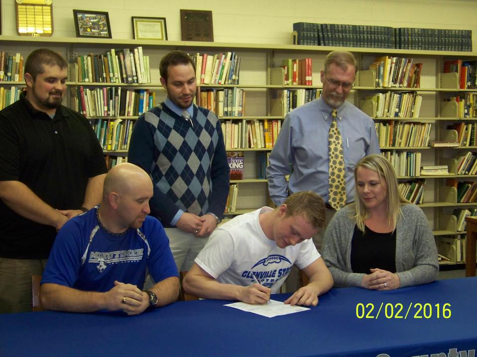 Damien White signs with GLS .  White is flanked by his parents Jeremy and Christina White.