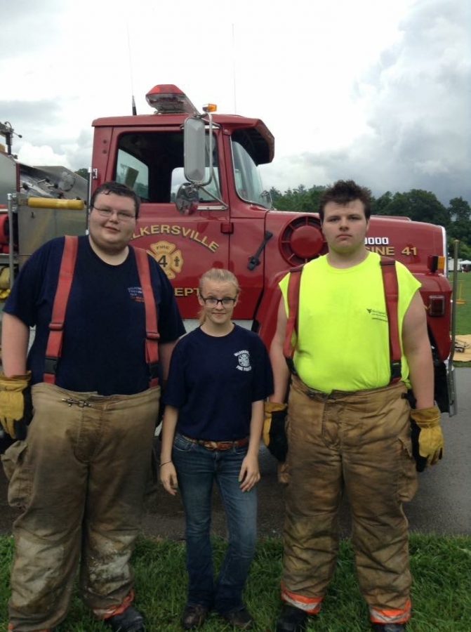 Jessie Jenkins is flanked by two volunteer firemen Nick Riffle (L) and Tyler Riffle (R).